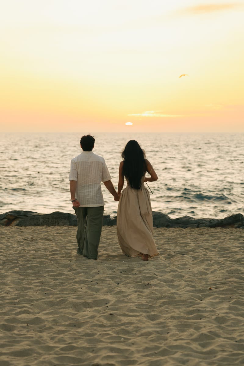 Holding hands on the beach at sunset